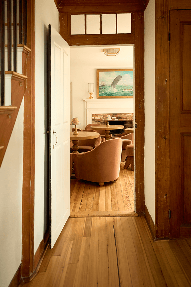 A doorway leads into a cozy living room with wooden floors and soft seating.